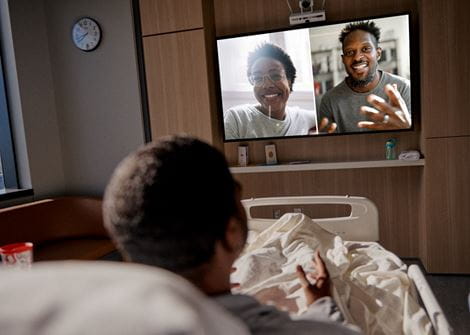 Patient in bed talking over webcam with family.jpg