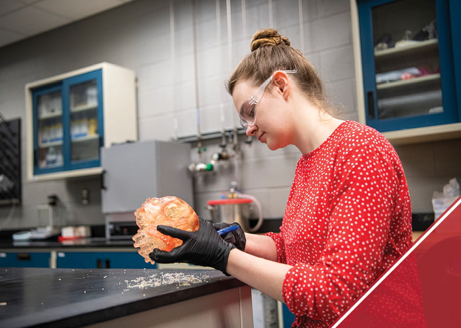 Woman working on a 3-D printed model of a human skull